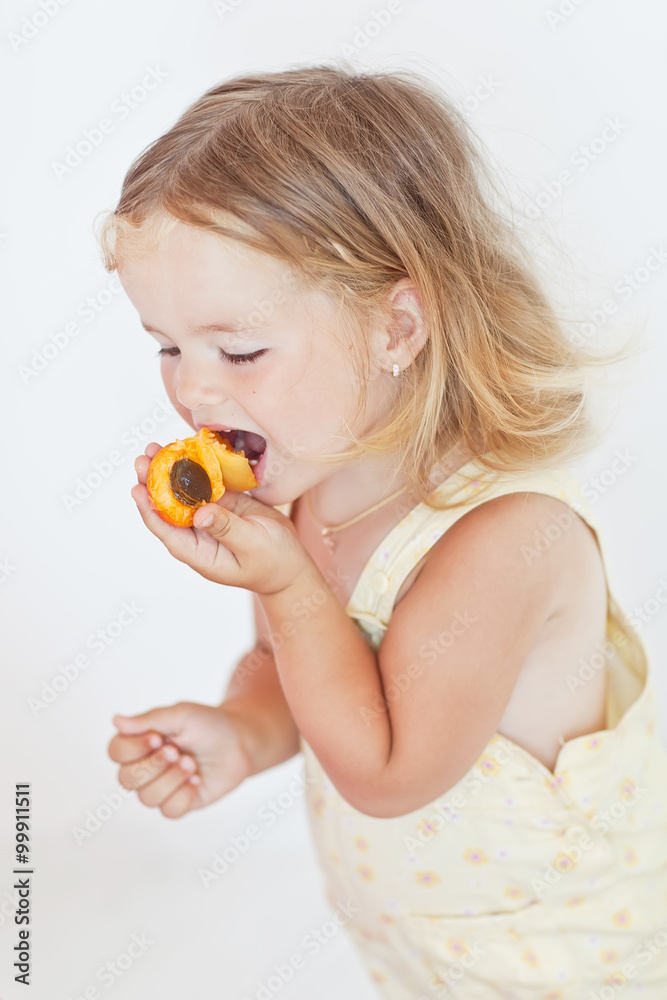 Happy little girl are eating fruits Happy little girl are eating fruits