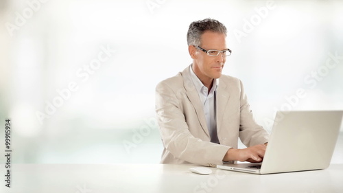 Elegant businessman is working on desk with his laptop    photo