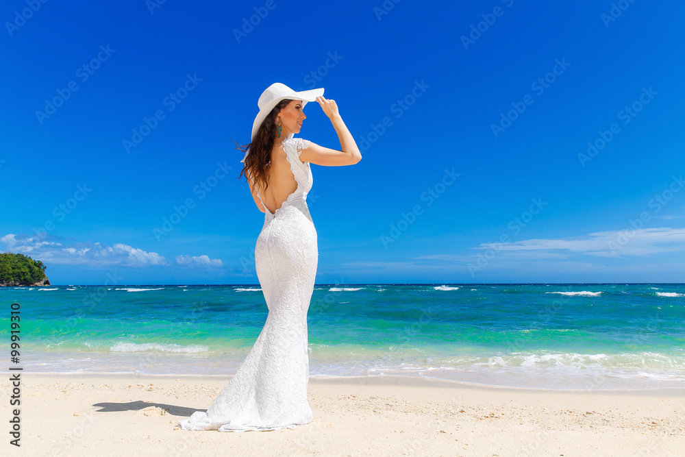 Beautiful brunette bride in white wedding dress and straw hat ha Beautiful brunette bride in white wedding dress and straw hat ha