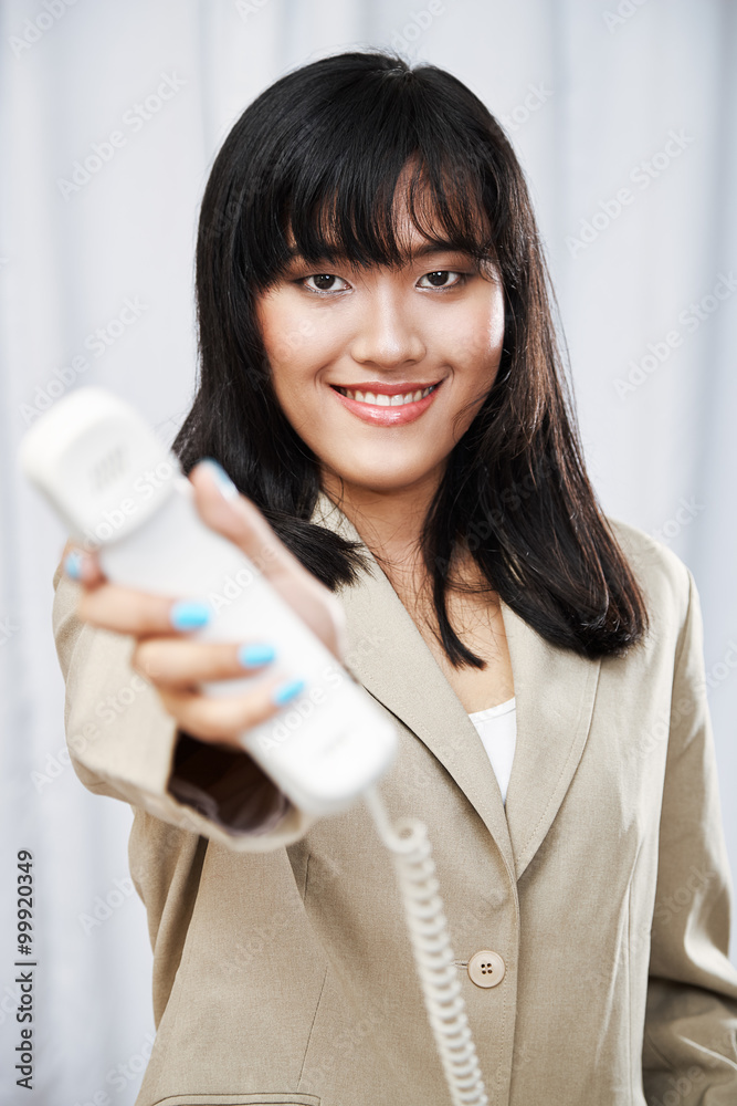 portrait of businesswoman handing telephone towards camera
portrait of businesswoman handing telephone towards camera