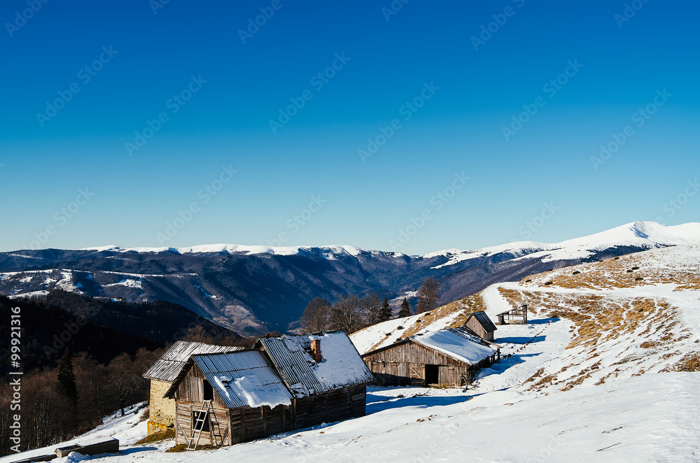 Old shepherd cabins in snowy winter Carpathian mountains in Ukraine