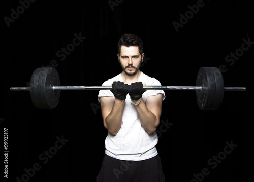 Man doing weight lifting in gym on black background. Close up of