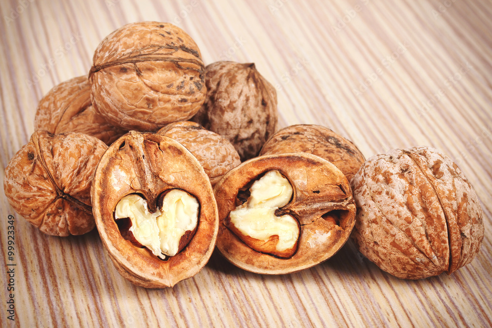 Group of cracked walnuts on wooden background Group of cracked walnuts on wooden background