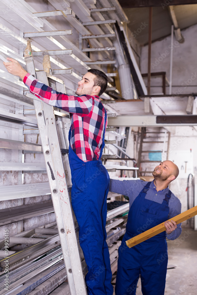 Fototapeta premium Two workers choosing PVC window profile