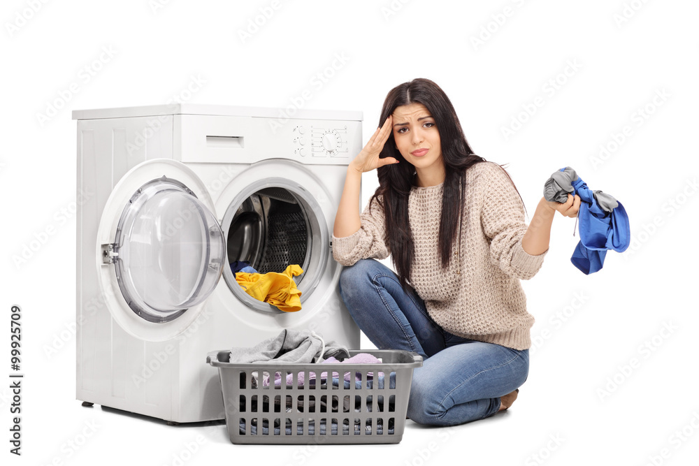 Sad woman emptying a washing machine