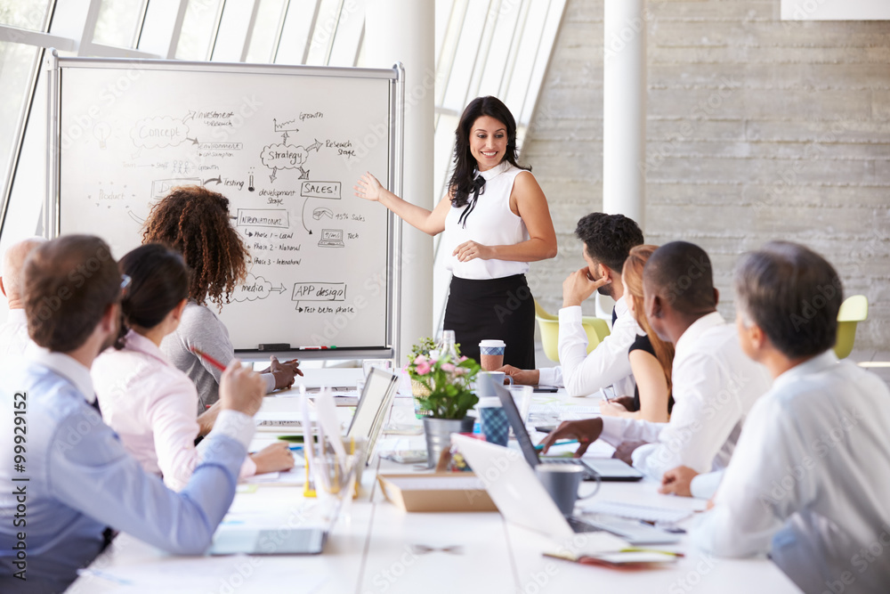 Hispanic Businesswoman Leading Meeting At Boardroom Table Hispanic Businesswoman Leading Meeting At Boardroom Table