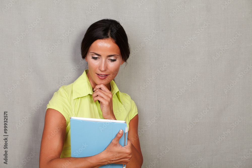 Pensive woman with hand on chin holding tablet Pensive woman with hand on chin holding tablet