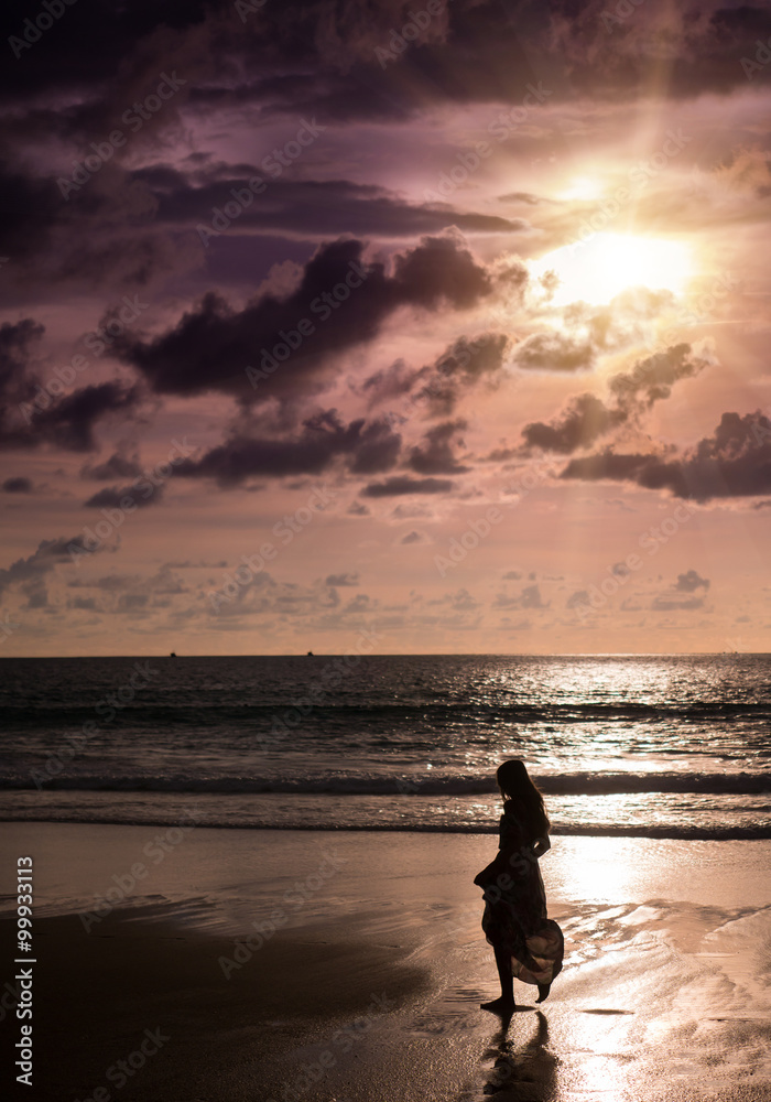 Young woman looking sunset on the beach in Phuket Thailand