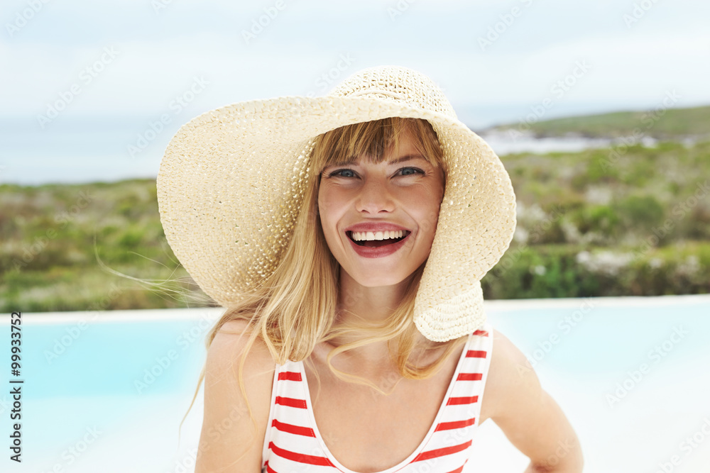 Laughing young lady in sunhat and swimsuit, portrait