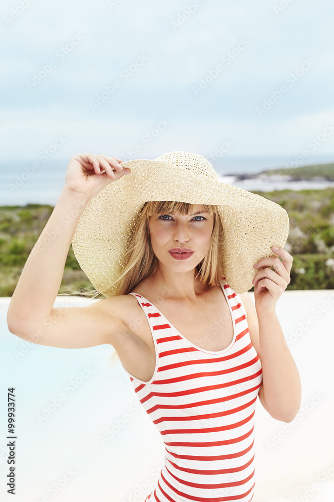 Posing young woman in sunhat and swimsuit, portrait
