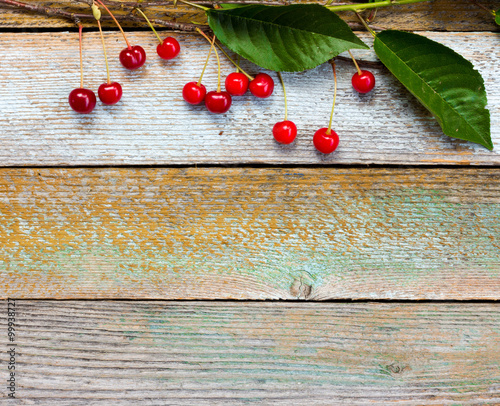 branch with red ripe cherries on a background of old barn boards. Copy space. Free space for text