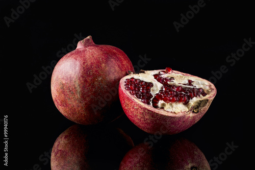 Ripe pomegranate on black background