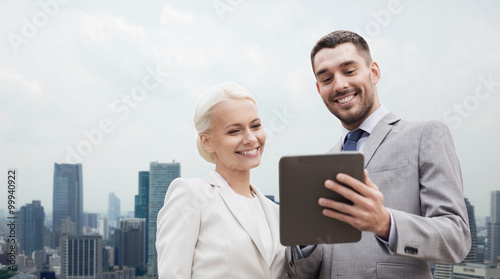smiling businessmen with tablet pc in city