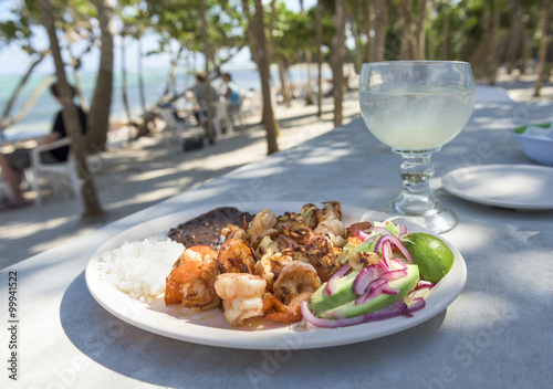Grilled Shrimp Platter on Beach:  A fresh platter of shrimp, grilled with garlic and butter with rice, beans, and avocado - on a beach covered with Palm Trees on Soliman Bay near Tulum, Mexico