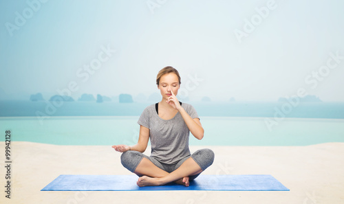 woman making yoga meditation in lotus pose on mat