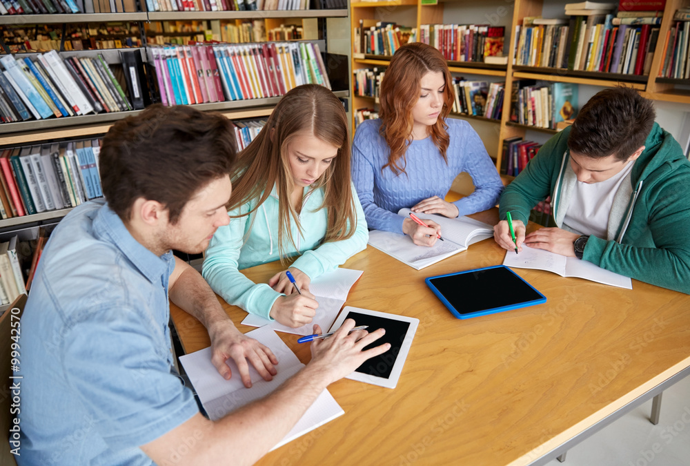 students writing to notebooks in library students writing to notebooks in library