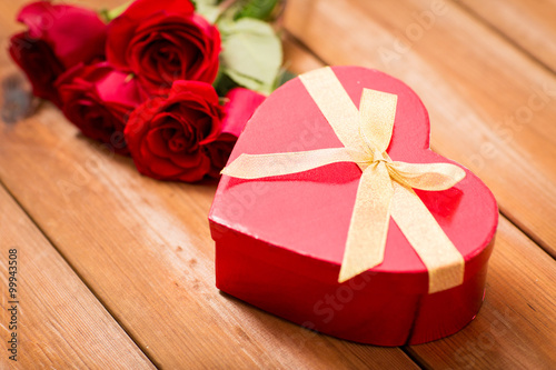 close up of heart shaped gift box and red roses