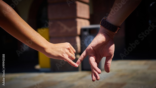Engaged couple walking in city and holding hands / Boy and girl holding hands with engagement ring