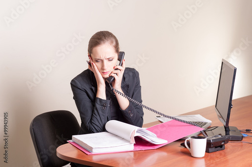 shocked woman talking on phone in office © pbogdanov