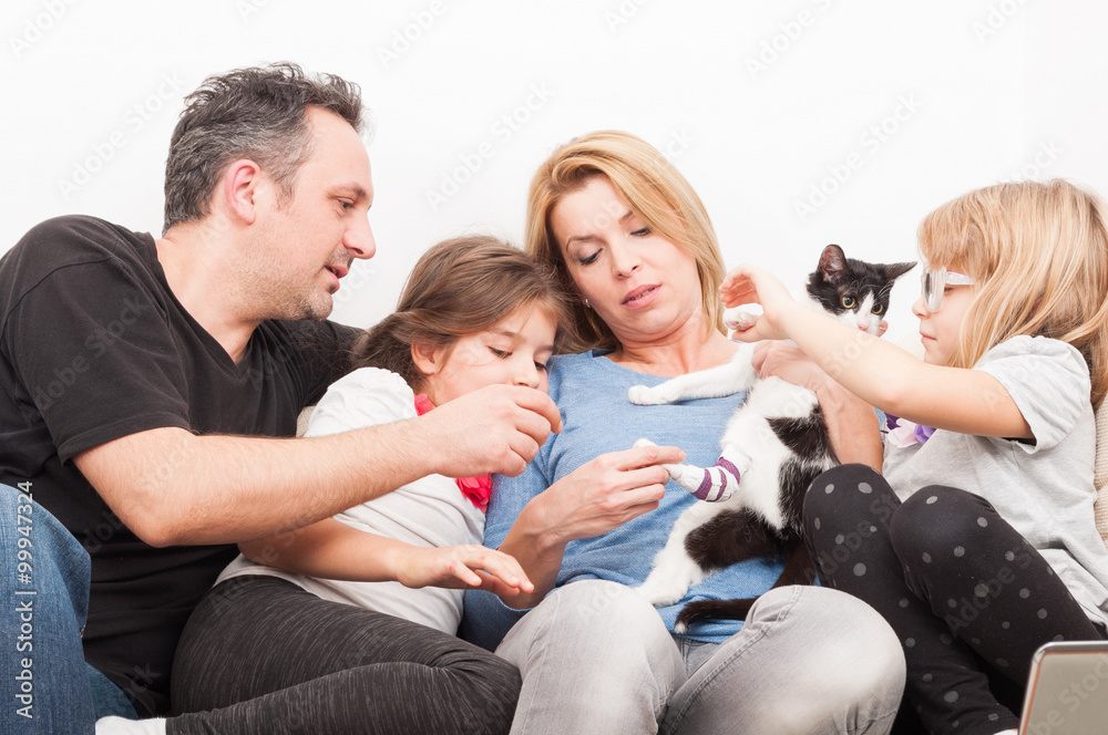 Happy family playing with cat or pet