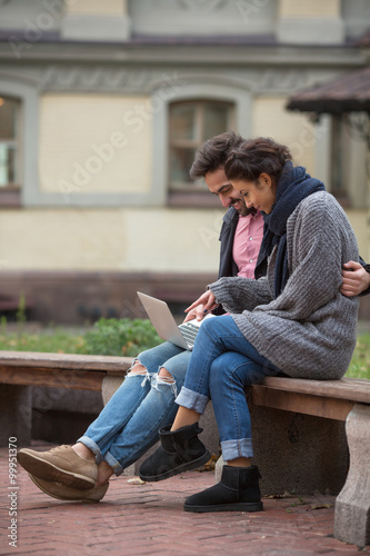 Happy couple surfing the Internet in the city