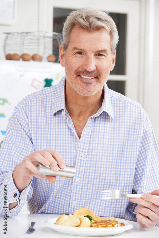 Man At Home Adding Salt To Meal Man At Home Adding Salt To Meal