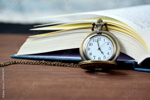 Vintage pocket watch and open book.