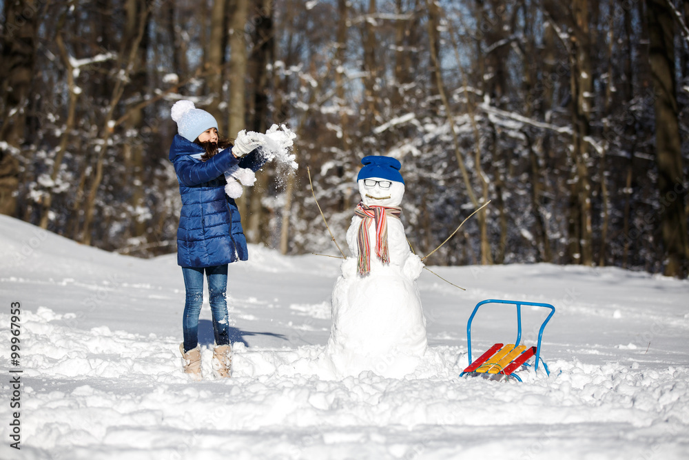 Little girl playing with a snowman Little girl playing with a snowman