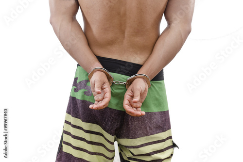 hands fettered with handcuffs isolated on white
