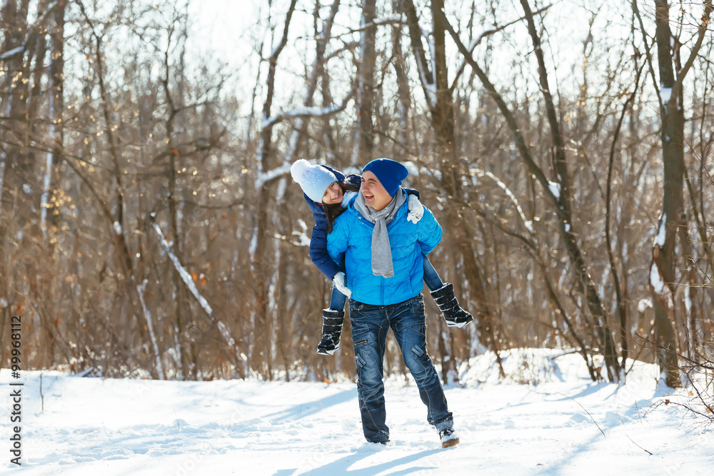 father and daughter playing in the snow in winter