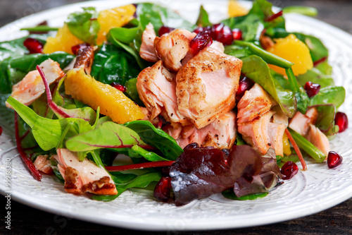 Fresh Salmon Salad with vegetables, pomegranate and orange.