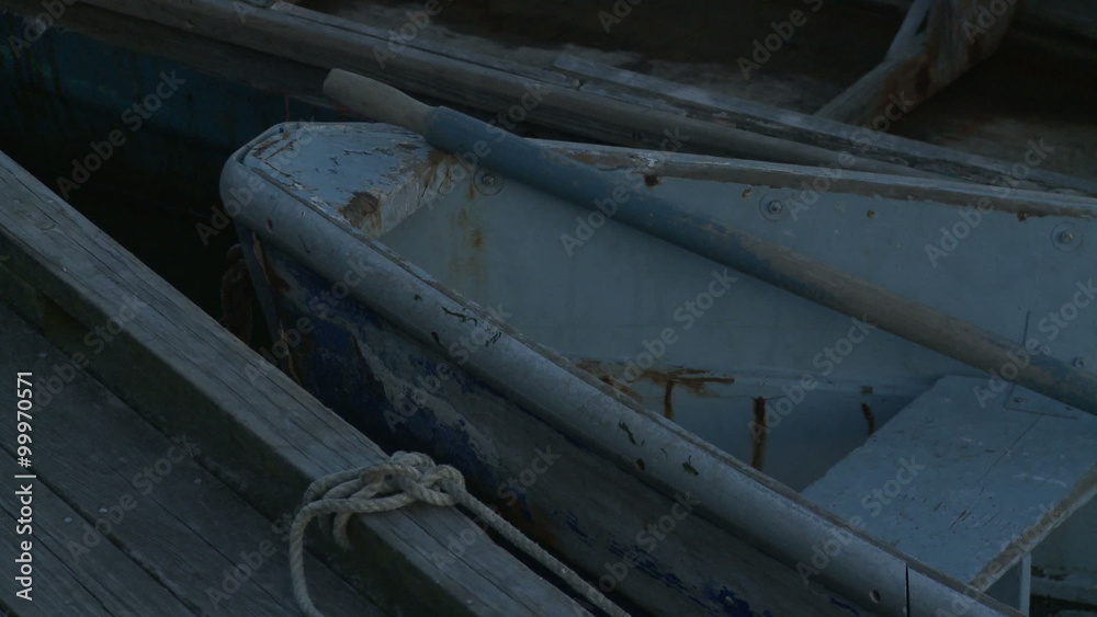 Close-up of two old, wooden rowboats tied to a dock. Close-up of two old, wooden rowboats tied to a dock.