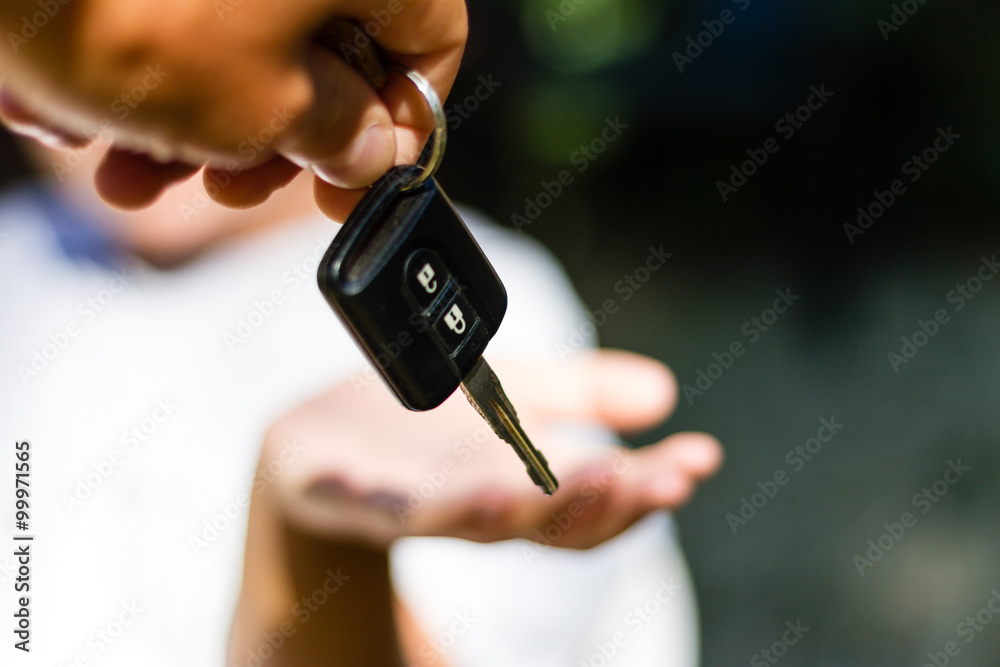 Fototapeta premium Young adult girl receives the key of her new car