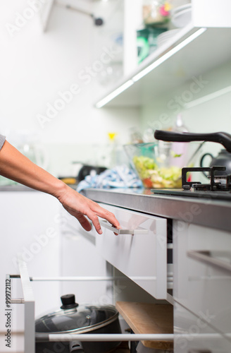 Young woman washing dishes in her modern kitchen