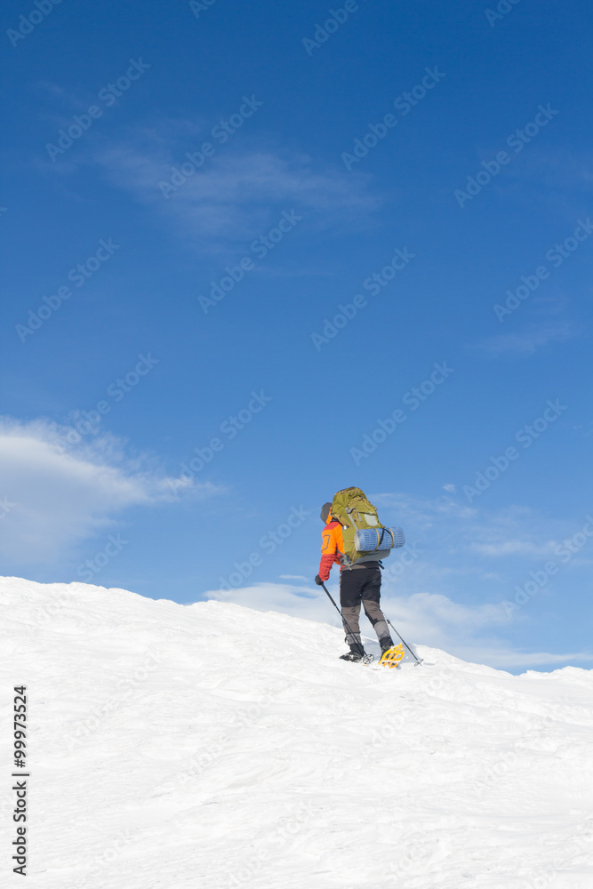 Winter hiking in the mountains on snowshoes with a backpack and tent. Winter hiking in the mountains on snowshoes with a backpack and tent.