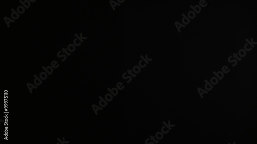 Hands using a film clapper board, on black, close up