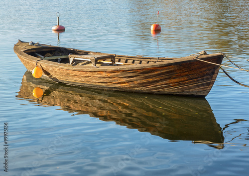 Obraz na plátně Traditional wooden rowboat in a lake on a sunny morning.