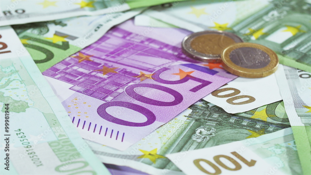 Two Euro coins over banknotes background rotating, loop ready Two Euro coins over banknotes background rotating, loop ready