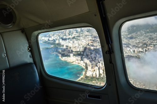 View from an airplane window on the city of Honolulu with Waikiki beach - Hawaii, USA. Selective focus on the airplane interior. Photo taken on a small commuter plane on the way from Oahu to Maui. © Juergen Wallstabe