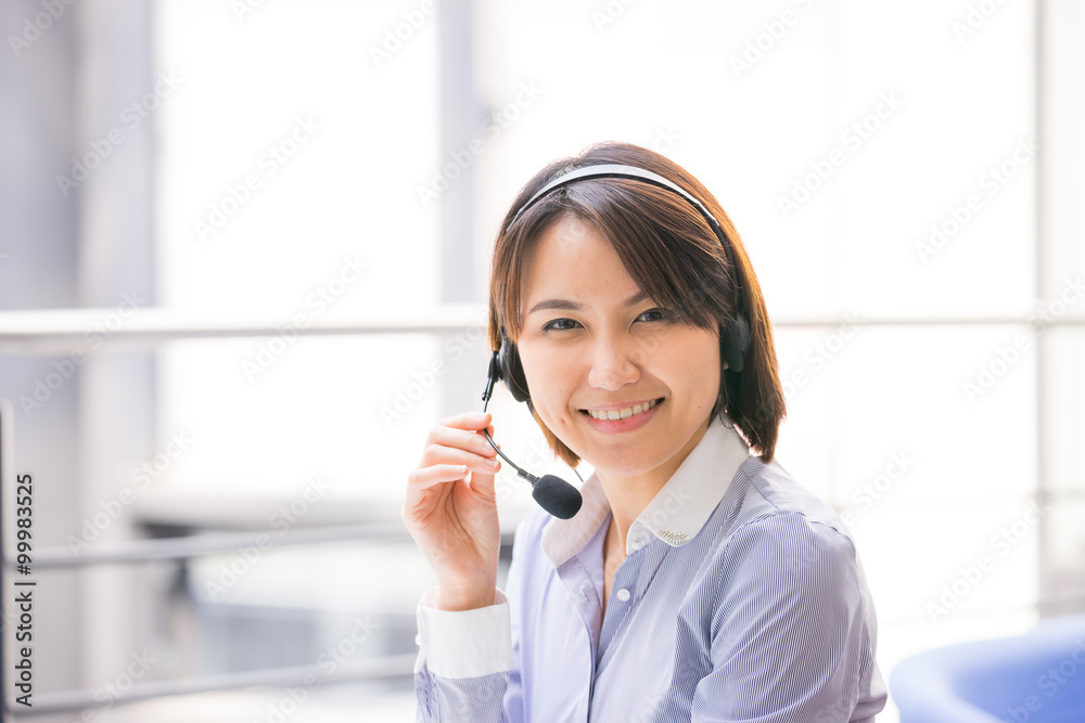 Asian Business woman talking using her headset in the office Asian Business woman talking using her headset in the office