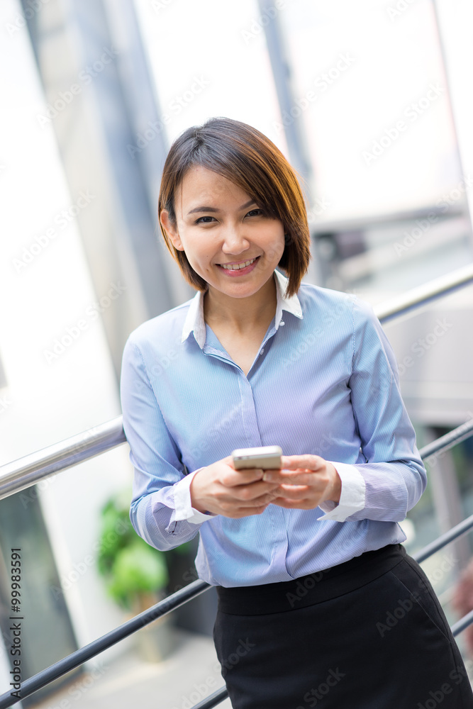 Asian businesswoman talking on a mobile phone at the office