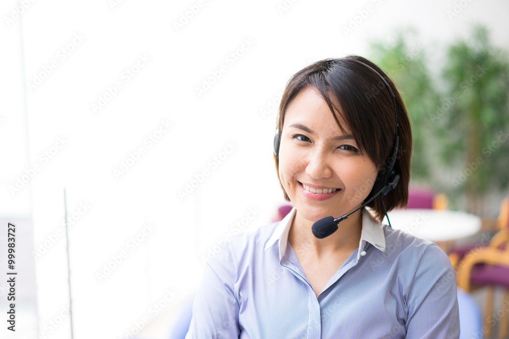 Asian Business woman talking using her headset in the office Asian Business woman talking using her headset in the office