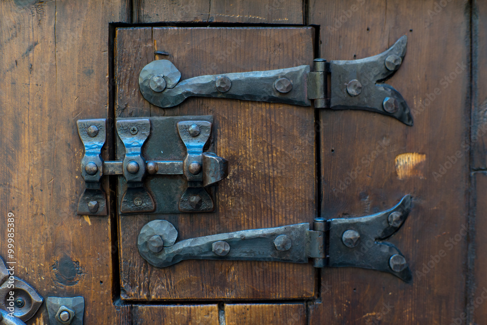 Medieval door lock. Oak door with iron lock.