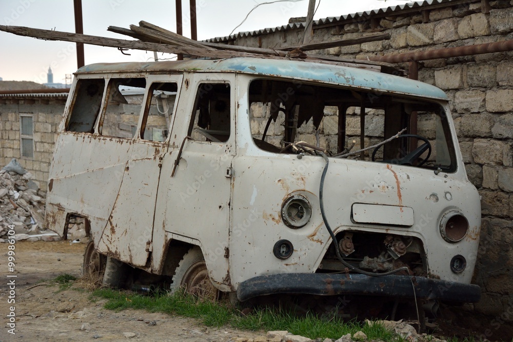 Rusting abandoned van in Baku, capital of Azerbaijan. A long abandoned van is slowly destroyed by nature

