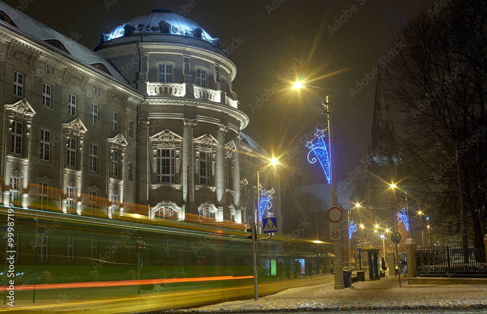 Street in front of the Medical University in PoznaÅ„ at night.