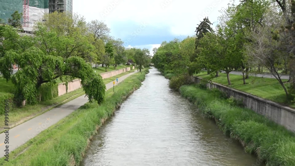Zoom out shot of an urban river with a bike path
Zoom out shot of an urban river with a bike path