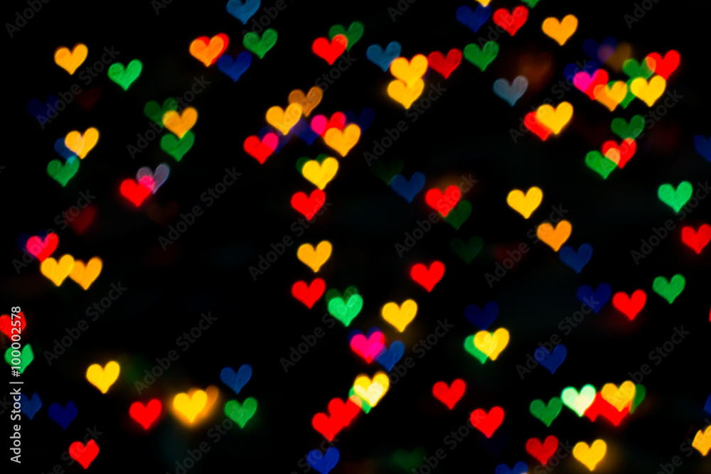 beautiful bokeh made of warm blurred lights in the form of hearts on dark background