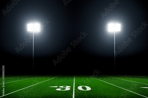 Football field illuminated by stadium lights