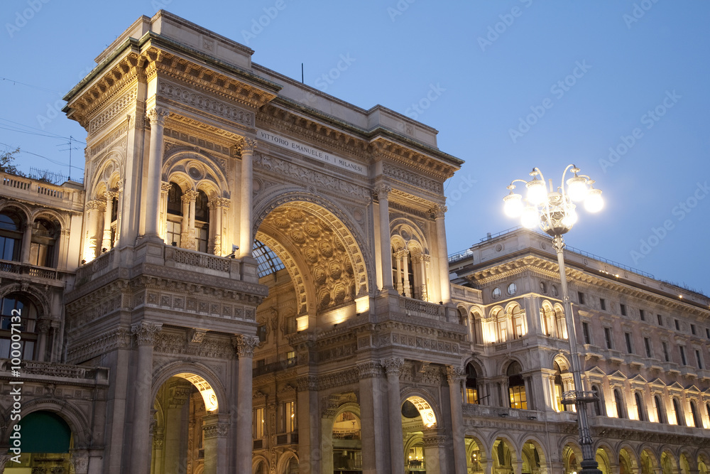 Entrance to the Vittorio Emanuele II Shopping Gallery in Milan, Italy, illuminated at night