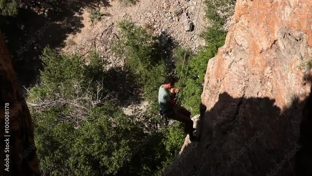 Handheld blurred shot of a rock-climber descending a cliff. Handheld blurred shot of a rock-climber descending a cliff.